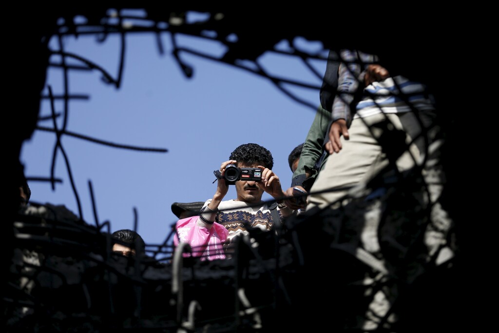 A journalist films the site of a Saudi-led air strike on a bridge in Yemen's capital Sanaa March 23, 2016.
