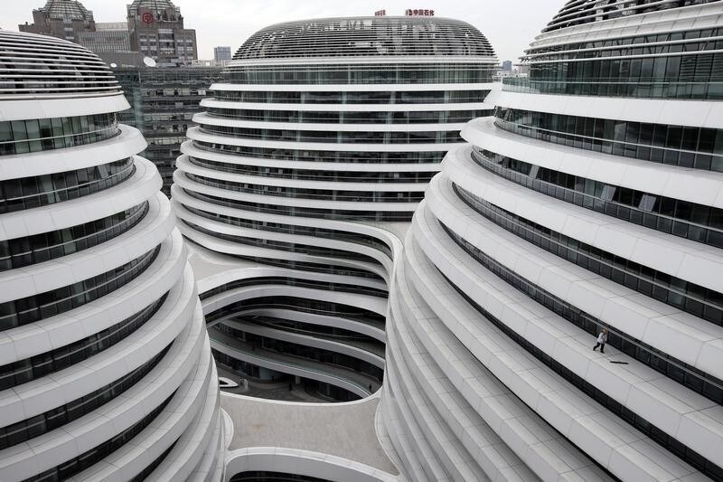A worker cleans an exterior of a newly built urban complex building accommodating offices and retail shops in Beijing October 14, 2013. REUTERS/Kim Kyung-Hoon (CHINA - Tags: BUSINESS CONSTRUCTION TPX IMAGES OF THE DAY) - GM1E9AE1BGU01
