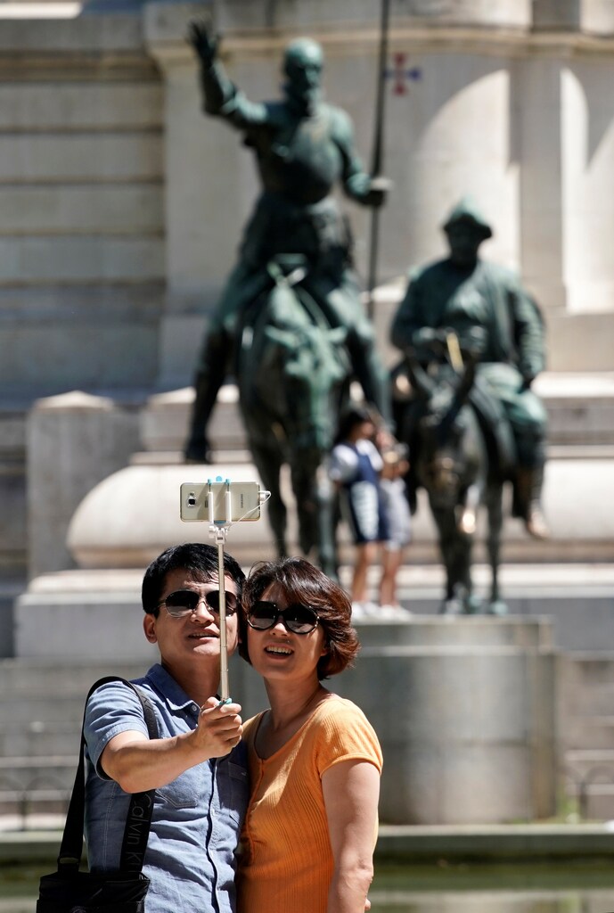 Tourists take selfies in Plaza de Espana square in Madrid, Spain, August 3, 2017. REUTERS/Paul Hanna - RTS1A9JV