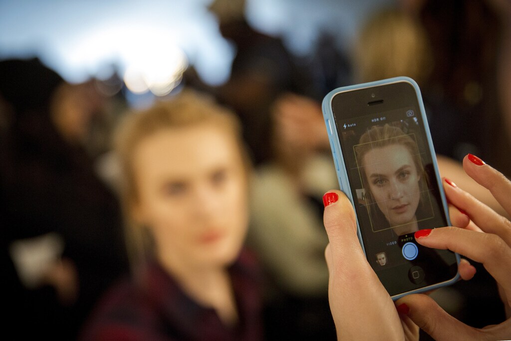 A make-up artist photographs a model backstage during preparations for the Jenny Packham Fall 2014 collection during New York Fashion Week February 11, 2014. REUTERS/Brendan McDermid (UNITED STATES - Tags: FASHION) - RTX18MWC
