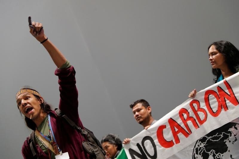 An activist speaks during a protest about the destruction brought by carbon markets and carbon offsets inside the venue of the U.N. climate change conference (COP25) in Madrid, Spain, December 5, 2019. REUTERS/Susana Vera - RC2YOD9UO614