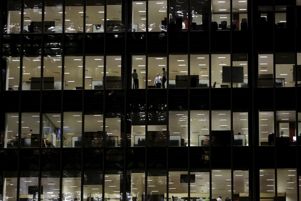 Workers are seen in office windows in the financial district of Canary Wharf in London November 3, 2015. REUTERS/Kevin Coombs - GF20000044453