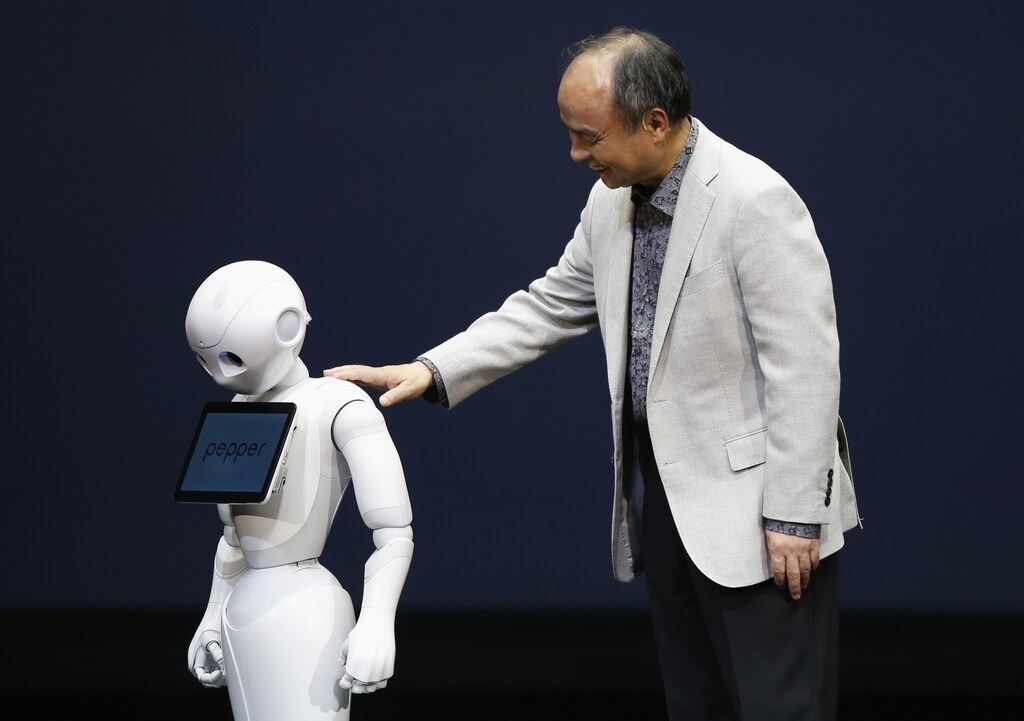 SoftBank Corp. Chief Executive Masayoshi Son (R) presents the company's human-like robots named 'pepper' during a news conference in Urayasu, east of Tokyo June 5, 2014. Japan's SoftBank Corp unveiled the human-like robots which it will use to staff its cellphone stores and personal usage at a home, in a move aimed at expanding the mobile phone and Internet conglomerate's technological reach. Son announced the plan at a news conference on Thursday, the robot will go on sale to public in Japan from February 2015, which price is about 198,000 yen. Softbank will use technologies developed by French robotics company Aldebaran, in which it took a stake in 2012. REUTERS/Issei Kato (JAPAN - Tags: SCIENCE TECHNOLOGY BUSINESS TELECOMS SOCIETY) - GM1EA6512JP01