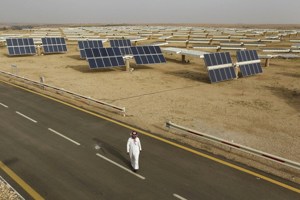 A Saudi man walks on a street past a field of solar panels at the King Abdulaziz city of Sciences and Technology, Al-Oyeynah Research Station May 21, 2012. Saudi Arabia, the world's top oil exporter, may finally be getting serious about overcoming the technical and financial hurdles for tapping its other main resource: sunshine. Saudi Arabia wants to generate much more solar power as it lacks coal or enough natural gas output to meet rapidly rising power demand. Doing so would allow it to slash the volume of oil it burns in power plants bankrolled by billions of dollars worth of saved oil earnings. Picture taken May 21, 2012. To match story SAUDI-SOLAR/ REUTERS/Fahad Shadeed (SAUDI ARABIA - Tags: ENERGY BUSINESS) growth