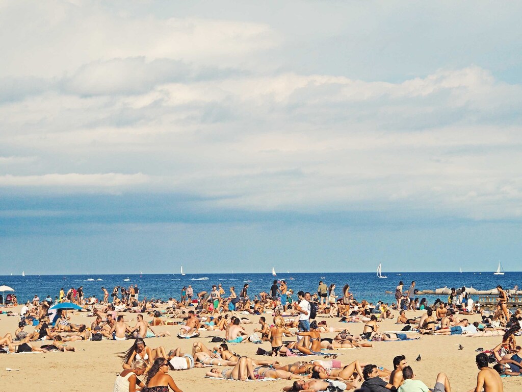 A hot and busy beach scene in Barcelona, Spain