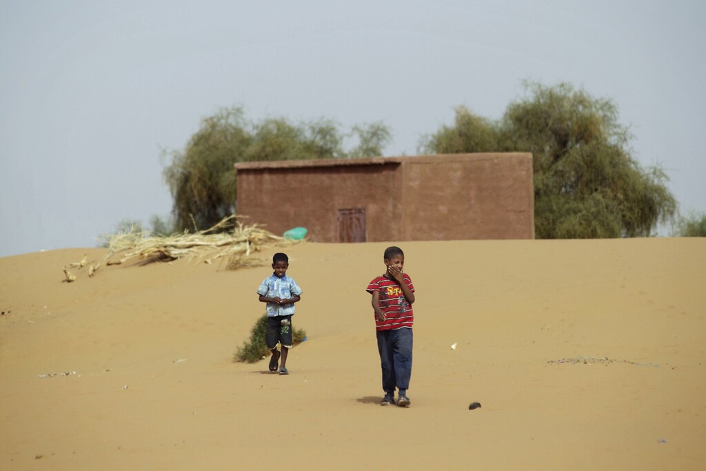 Boys walk on desert sands in the town of Moghtar-Lajjar May 25 2012. Civil unrest and a drought in west Africa's Sahel region have put 15 million people in food insecurity, according to the United Nations.