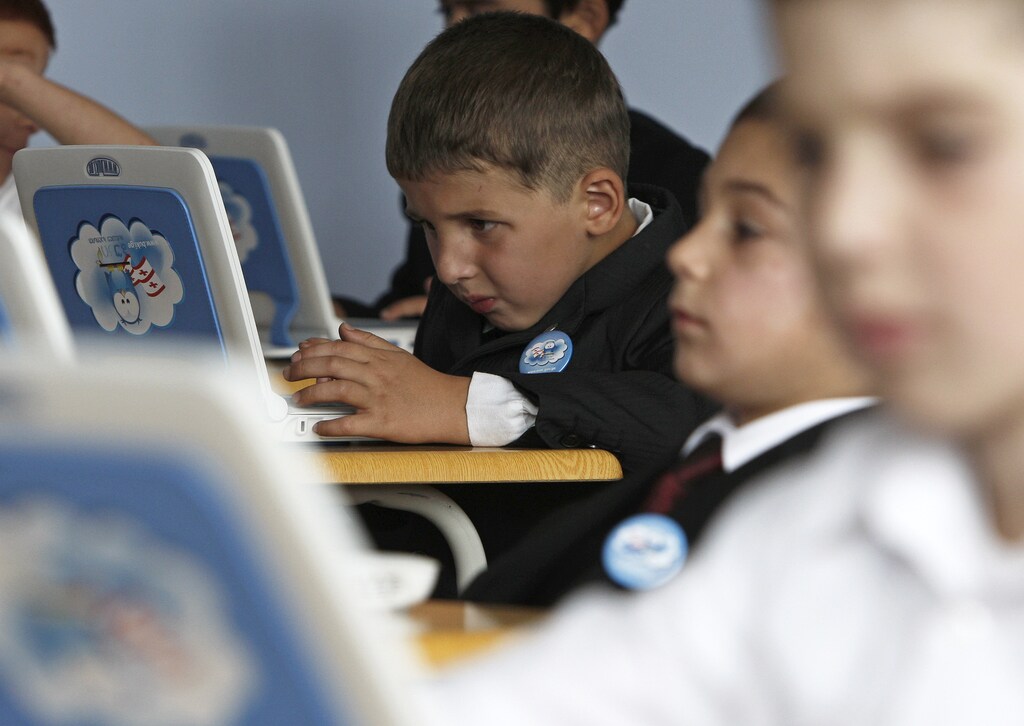 First graders attend their first English language lesson at a local school in Tbilisi, September 15, 2010. On Wednesday, hundreds of native English speakers joined the first day of school as teaching assistants under an ambitious program to have every child aged five to 16 speak English. English is now compulsory, and Russian optional. REUTERS/David Mdzinarishvili (GEORGIA - Tags: SOCIETY EDUCATION IMAGES OF THE DAY) - RTR2ICZA