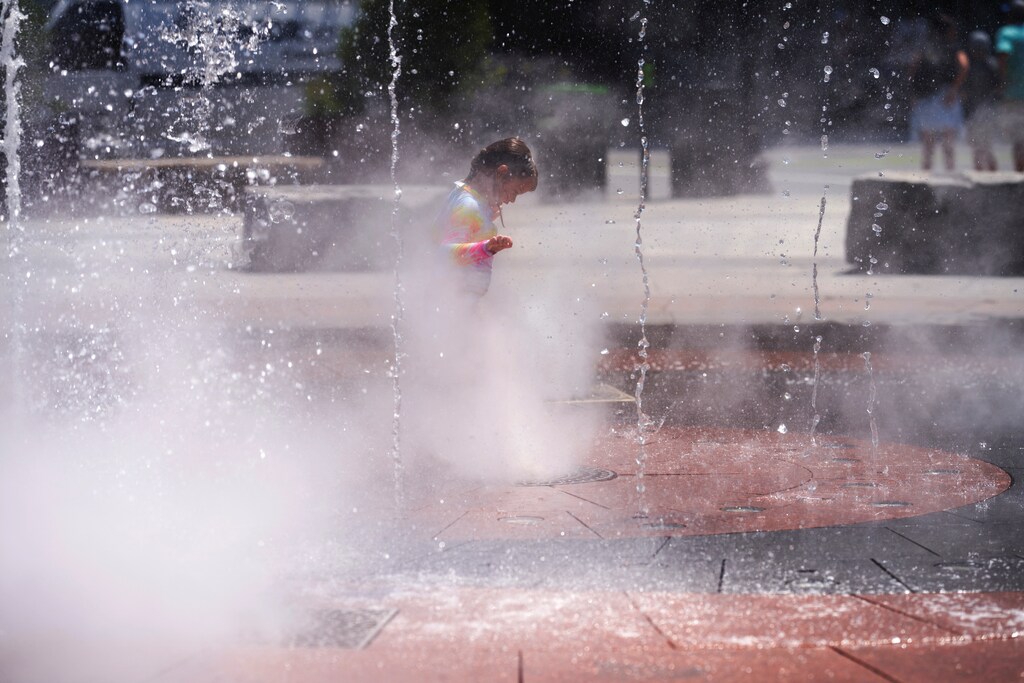 A child plays in a water fountain, during a heatwave, in Boston, Massachusetts, U.S. July 21, 2022. REUTERS/Allison Dinner