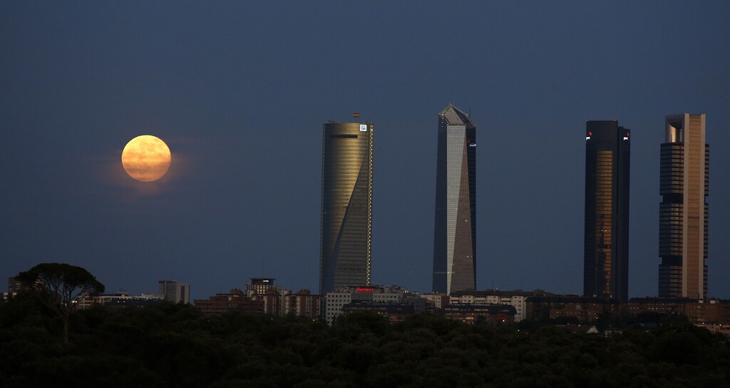A "super moon" rises near the Four Towers business district in Madrid, June 23, 2013. On Sunday a perigee moon coincides with a full moon creating a "super moon" when it will pass by the earth at its closest point in 2013. REUTERS/Paul Hanna (SPAIN - Tags: ENVIRONMENT CITYSCAPE) - RTX10YJ6