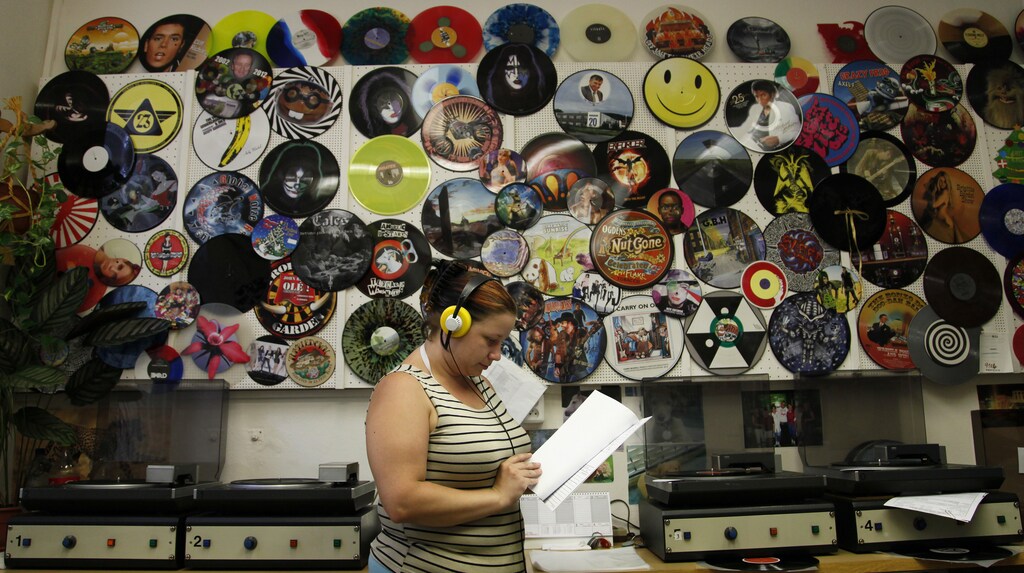 Employee Petra Kottova checks the sound quality of a pressed vinyl record at the GZ Media factory in Lodenice August 1, 2013. With 7 million records made in 2012 and an expected 10 million this year, GZ Media says it is the world's biggest vinyl record producer, making records for Universal Music Group, Sony Music and now beginning to cooperate with Warner Music. Picture taken August 1, 2013. To match MUSIC-VINYL/CZECH REUTERS/Petr Josek (CZECH REPUBLIC - Tags: BUSINESS EMPLOYMENT) - GM1E98J1RUV01
