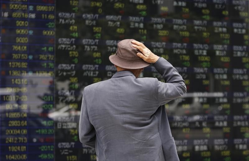 A man looks at a stock quotation board outside a brokerage in Tokyo May 11, 2012. Asian shares retreated on Friday, spooked by JPMorgan's $2 billion loss from a failed hedging strategy, with investors warily watching political turmoil in the euro zone as they await new Chinese data for clues on its growth outlook. REUTERS/Toru Hanai (JAPAN - Tags: BUSINESS) - RTR31W5I