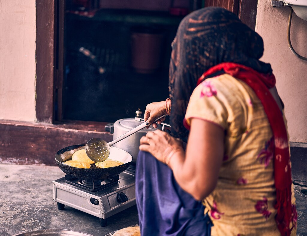 A woman in ghoonghat cooking Pooris; e-cooking