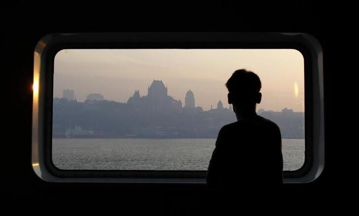 A man looks through a window as smoke covers the skyline of Quebec City May 30, 2010. A smoke cloud coming from the forest fires of Wemotaci was blown over Quebec City by high North West winds, according to Environment Canada. REUTERS/Mathieu Belanger (Canada - Tags: ENVIRONMENT SOCIETY IMAGES OF THE DAY)