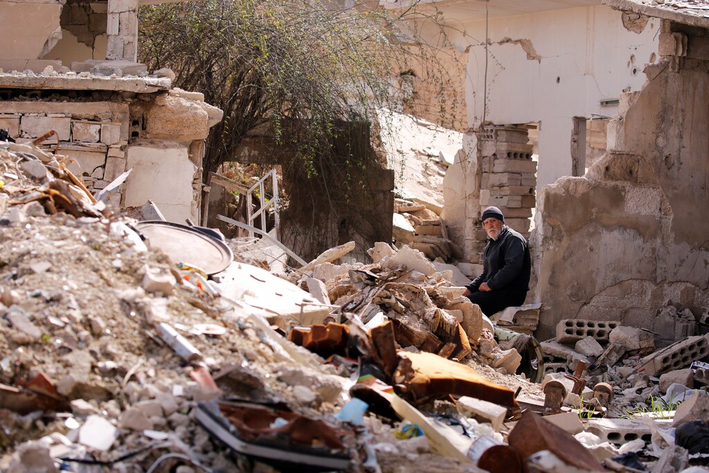 A man sits near rubble of damaged buildings in Ein Terma, a district of eastern Ghouta, Syria February 26, 2019. Picture taken February 26, 2019. REUTERS/Omar Sanadiki - RC1C1C8F8280
