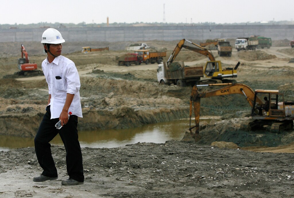 A Chinese engineer watches the excavation process at the construction site for the new deep water shipping port in Hambantota, 240 km (150 miles) southeast of Colombo, March 24, 2010. The port is a joint venture between Sri Lanka and China, and when completed, will be the largest port in the country and expects to attract more then 100 vessels a day. China was the largest foreign funding source for Sri Lanka in 2009 with $1.2 billion. REUTERS/Andrew Caballero-Reynolds (SRI LANKA - Tags: POLITICS BUSINESS TRANSPORT CONSTRUCTION) - GM1E63O1TAG01