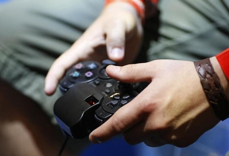 A visitor plays with a 'Playstation' at an exhibition stand at the Gamescom 2009 fair in Cologne August 22, 2009. The Gamescom convention, Europe's leading fair for computer games, runs from August 19 to August 23. REUTERS/Ina FAssbender (GERMANY ENTERTAINMENT SOCIETY)