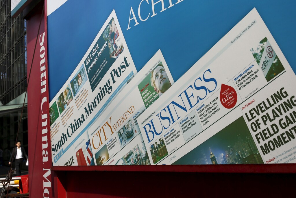 A man walks past an advertisement of South China Morning Post (SCMP) newspaper in Hong Kong, China November 26, 2015. Chinese e-commerce titan Alibaba Group Holding Ltd has approached the publisher of Hong Kong's South China Morning Post newspaper to discuss buying its media assets, a source familiar with the matter said on Thursday. REUTERS/Tyrone Siu - RTX1VW37