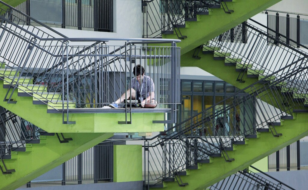 A journalist works on a staircase at the Singapore Sports School, the venue of the FINA Swimming World Cup, in Singapore November 5, 2011.