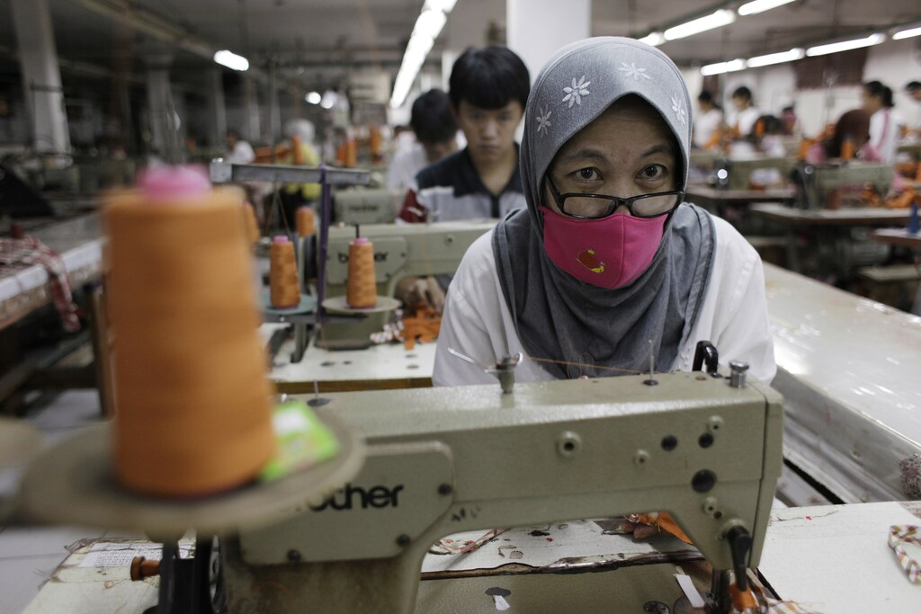 A worker makes clothes in a factory at Cakung, a small industrial settlement in Jakarta August 6, 2012. Indonesia's economic growth surprisingly picked up in the second quarter of this year, signalling that Southeast Asia remains resilient to the global slowdown. Indonesia's statistics bureau said gross domestic product growth last quarter was 6.4 percent from a year earlier against 6.3 percent in the first quarter, helped by domestic consumption and investment. GDP grew by 2.8 percent on a quarterly basis, although the figures are not seasonally adjusted. REUTERS/Beawiharta (INDONESIA - Tags: BUSINESS TEXTILE) - RTR368WA