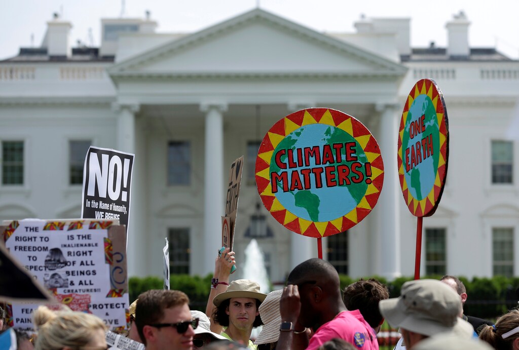 Protesters carry signs during the Peoples Climate March at the White House in Washington, U.S., April 29, 2017. REUTERS/Joshua Roberts - RTS14HJJ