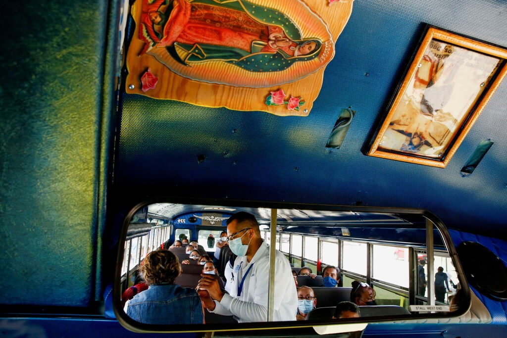 Employees of an assembly factory are seen reflected in the mirror of a bus as they receive a dose of the Pfizer-BioNTech coronavirus disease (COVID-19) vaccine in Ciudad Juarez, Mexico May 24, 2021. REUTERS/Jose Luis Gonzalez TPX IMAGES OF THE DAY - RC2EMN9IJ0JC