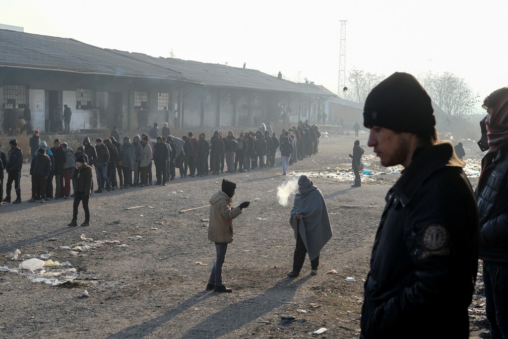 Migrants stand in line to receive free food outside a derelict customs warehouse in Belgrade, Serbia December 21, 2016. REUTERS/Marko Djurica - RTX2W0KD