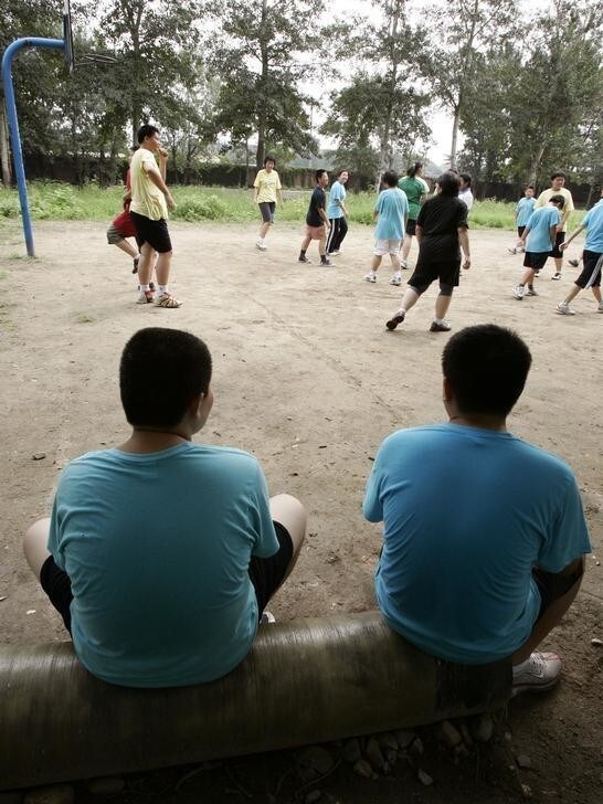 Boys watch their colleagues play at OK Slim summer camp on the outskirts of Beijing August 3, 2006. Some 40 obese children stayed in the camp for 30 days to lose weight at a cost of 6,600 yuan (825 US dollars) on average. The Ministry of Education statistics last year showed that 11.5 per cent of urban Chinese boys aged 7 to 22 were obese, and so were 8 per cent of urban girls of the same age group, China Daily reported. REUTERS/Claro Cortes IV (CHINA)