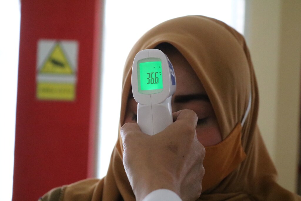 A lady having her temperature taken, illustrating the importance of preventing epidemics