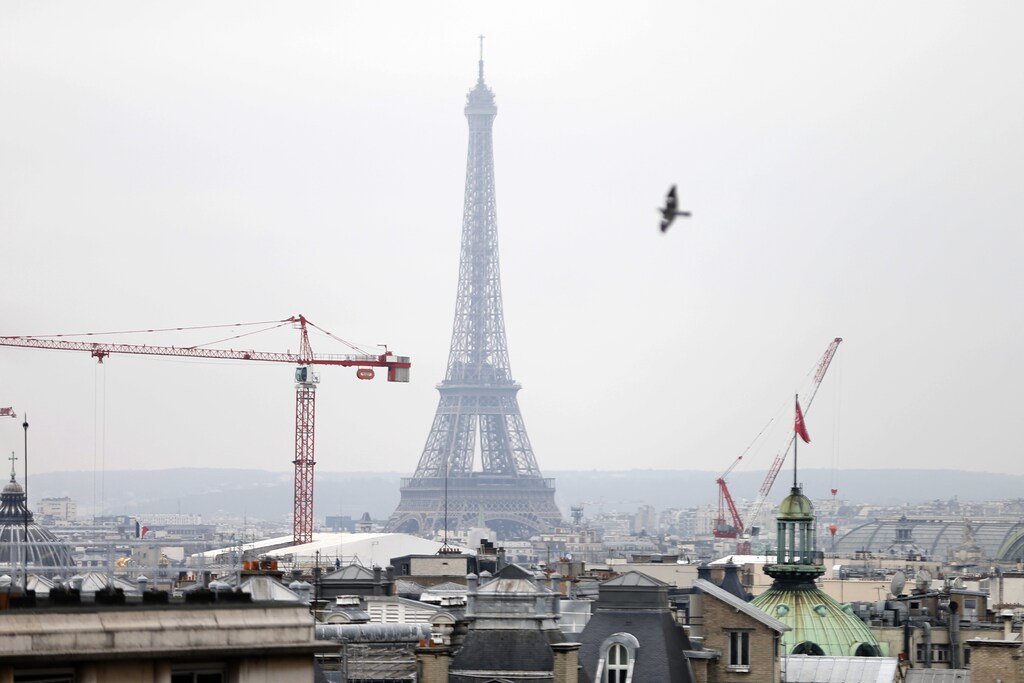 A general view shows the Eiffel tower, construction site's cranes and the Paris skyline March 17, 2014. France deployed hundreds of police in Paris on Monday to enforce the most drastic curbs on car use in 20 years as authorities sought to reduce health-endangering pollution days before town hall elections. Amid concerns of a worsening air quality after a week when unseasonally balmy weather boosted pollution, public transport was free of charge while drivers with even-numbered licence plates were told to leave their cars at home of face fines. REUTERS/Charles Platiau (FRANCE - Tags: TRANSPORT ENVIRONMENT) - PM1EA3H15MP01