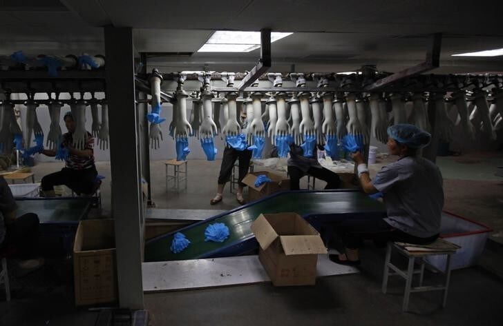 Workers operate on a rubber glove assembly line at a factory in Zibo, Shandong Province May 28, 2012. China's industrial sector increasingly runs by machine, which might seem like the perfect answer to China's fast-rising labour costs - they don't ask for a raise, get injured or go on strike. According to Nomura, 28 percent of factory machines in China use numerical controls - one measure of automation. That may be far lower than Japan's 83 percent, but China is growing far faster than Japan did at a comparable stage of development, says Ge Wenjie, a machinery analyst with Nomura. Picture taken on May 28, 2012. To match Analysis CHINA-ECONOMY/AUTOMATION REUTERS/Aly Song (CHINA - Tags: BUSINESS)