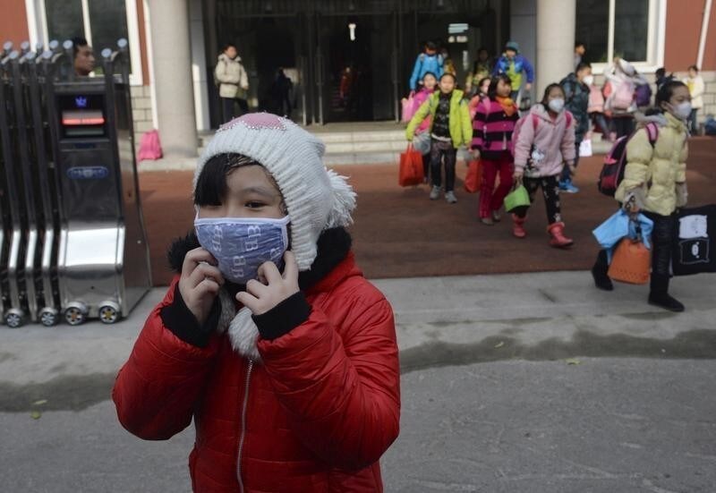 School children wearing masks leave school early at noon due to heavy air pollution, at a primary school in Shenyang, Liaoning province, November 13, 2015. According to Xinhua News Agency, lingering smog has disrupted traffic in northeast China's Liaoning Province, closing highways and delaying trains. REUTERS/Stringer CHINA OUT. NO COMMERCIAL OR EDITORIAL SALES IN CHINA - GF20000057495