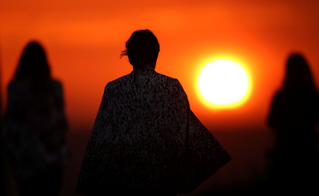 A group of women watch the sun set over the ocean in Laguna Beach, California October 24, 2016.