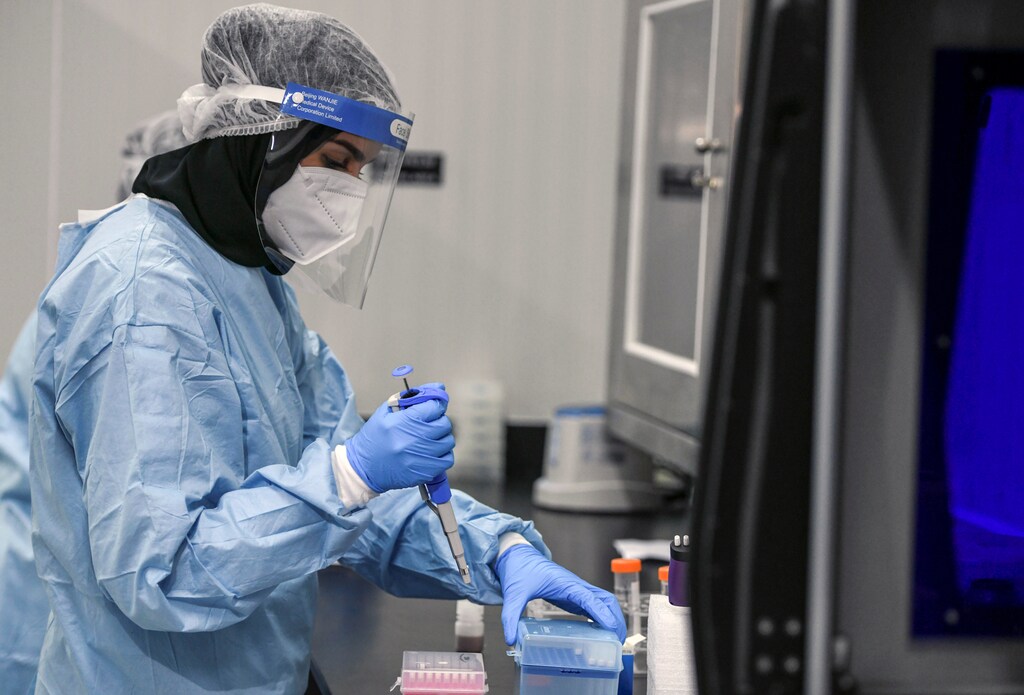 A medical worker wearing protective suit and face shield carries out tests at the Biogenix Laboratories, which performs COVID-19 detection tests, in Masdar City, Abu Dhabi, United Arab Emirates, October 6, 2020. Picture taken October 6, 2020. REUTERS/Khushnum Bhandari. - RC2AEJ9F1STJ