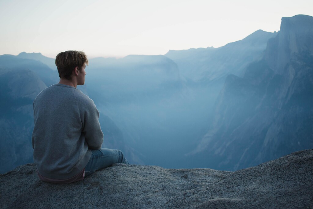 Man sitting on top of a mountain