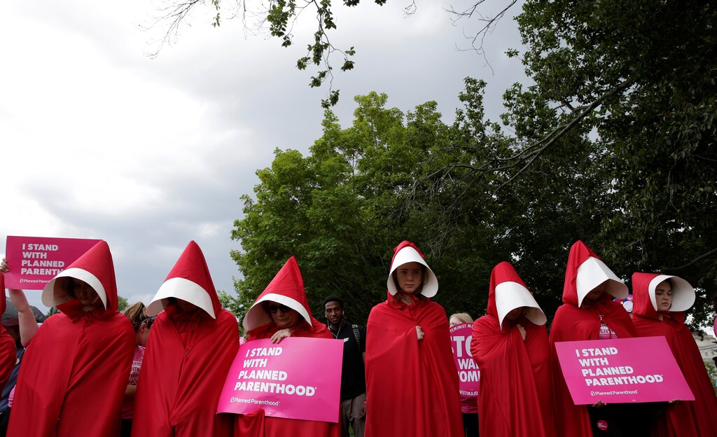 Women dressed as handmaids from the novel, film and television series "The Handmaid's Tale" demonstrate against cuts for Planned Parenthood in the Republican Senate healthcare bill at the U.S. Capitol in Washington, U.S., June 27, 2017. REUTERS/Joshua Roberts