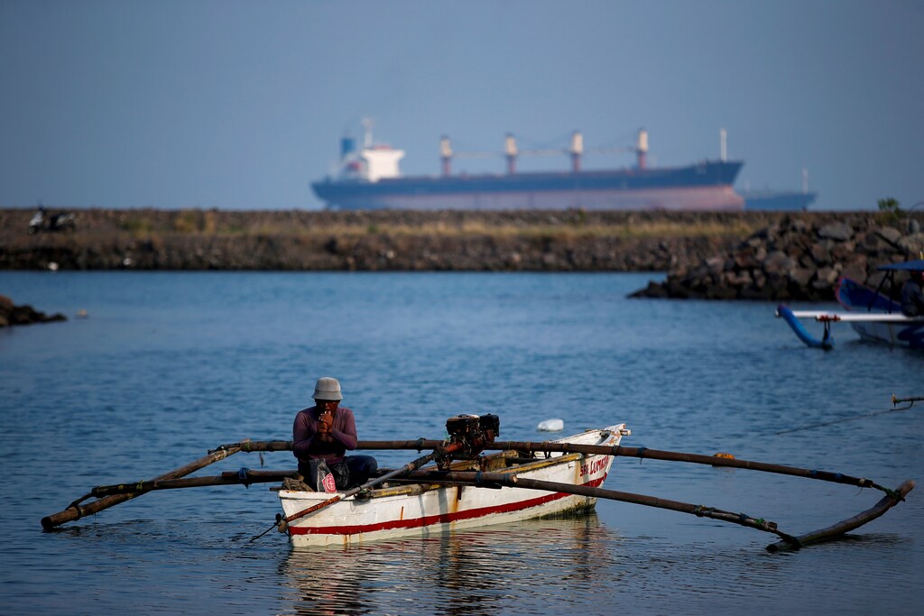 Ramidin, 59, a local fisherman, smokes a cigarette as he prepares for fishing at a port near the coal-fired power plant owned by Indonesia Power in Suralaya, Banten province, Indonesia, July 11, 2020. Picture taken July 11, 2020. REUTERS/Willy Kurniawan - RC25UH96SRII