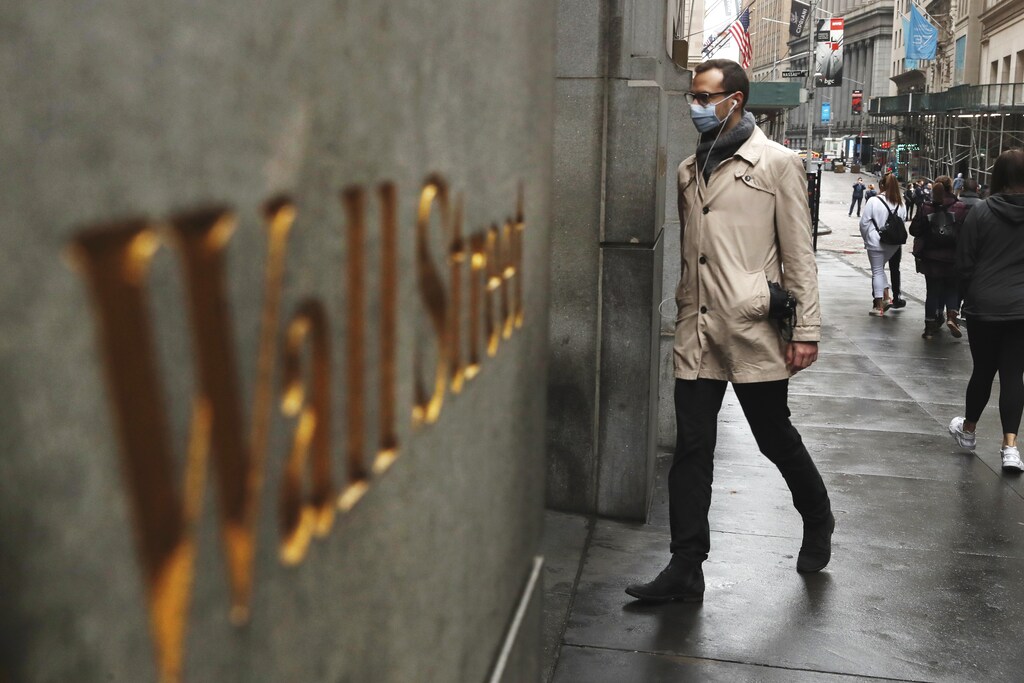A man wears a protective mask as he walks on Wall Street during the coronavirus outbreak in New York City, New York, U.S., March 13, 2020. REUTERS/Lucas Jackson - HP1EG3D18FND0