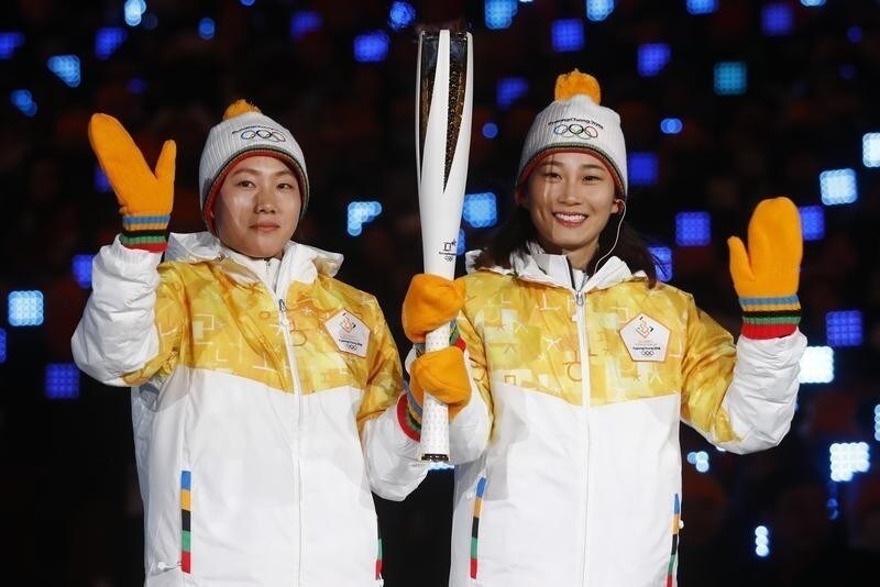 Hockey players from the unified Korean team wave during the opening ceremony. REUTERS/Kai Pfaffenbach - DEVEE2910UAYP