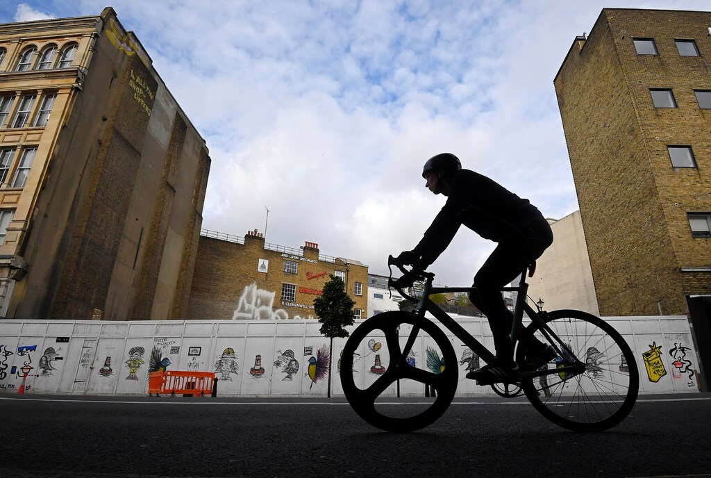A cyclist rides past a boarded-up petrol station, used as an open-air cinema as well as a car wash since its closure, now awaiting commercial redevelopment in a prime real estate location in the Clerkenwell district of central London, Britain, October 26, 2016. REUTERS/Toby Melville SEARCH "MELVILLE GAS" FOR THIS STORY. SEARCH "THE WIDER IMAGE" FOR ALL STORIES - RTX2V02L
