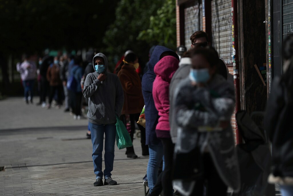 People queue to receive donated food from volunteers of Vecinos Parque Aluche association as the spread of the coronavirus disease (COVID-19) continues in Madrid, Spain, May 16, 2020. REUTERS/Susana Vera - RC2OPG9D5JA6