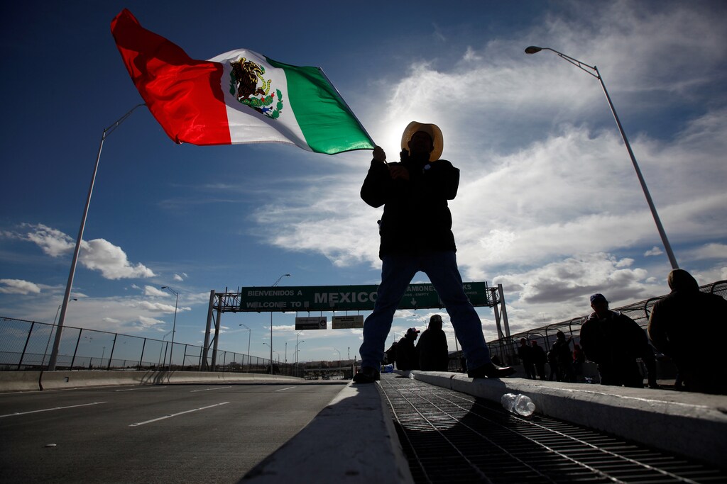A farmer waves a Mexican flag while blocking the Bridge of the Americas border crossing between Ciudad Juarez, Mexico and El Paso, U.S., during a protest against a fuel price hike in Ciudad Juarez, Mexico January 20, 2017. REUTERS/Jose Luis Gonzalez