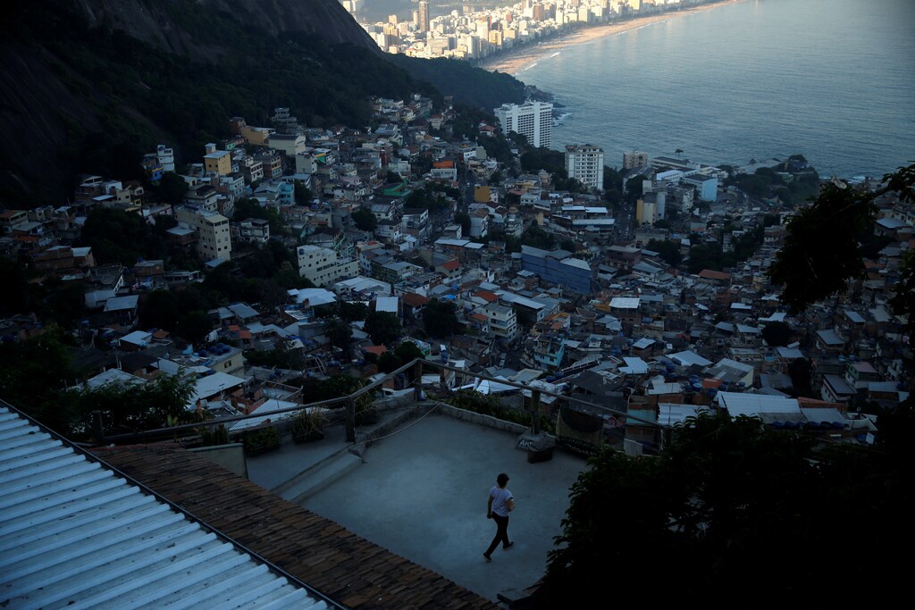 A guest walks along a terrace at Alto Vidigal hostel in Vidigal favela, in Rio de Janeiro, Brazil, April 23, 2016. Hostels in a few of RioÕs more than 1,000 slums serve not only as a cheap housing alternative for the more adventurous among the estimated 500,000 foreign tourists expected to arrive for the Olympics in August. The establishments also open up the rich culture of the city's shantytowns for travellers, giving them a glimpse into once "no-go" areas where about one-fifth of Rio's population lives. REUTERS/Pilar Olivares SEARCH "HOLIDAY FAVELAS" FOR THIS STORY. SEARCH "THE WIDER IMAGE" FOR ALL STORIES - S1BETBYEYYAA