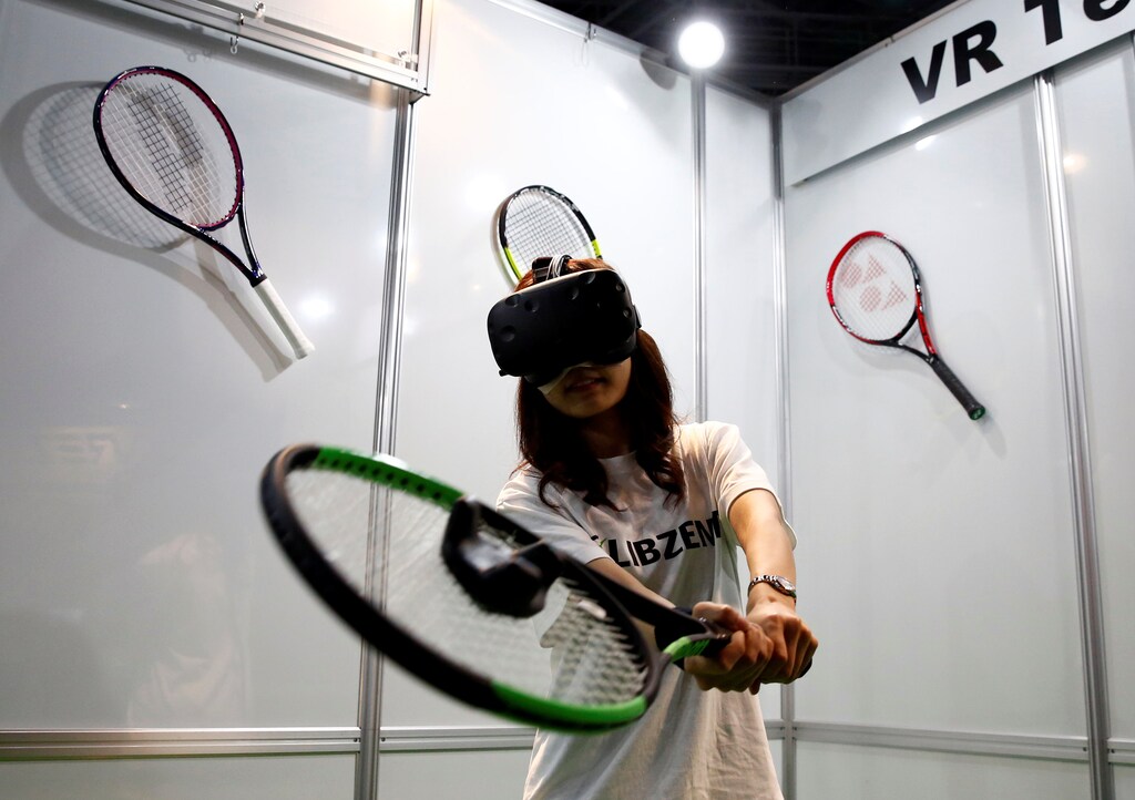 A woman demonstrates LIBZENT Innovations' VR Tennis trainer at VR/AR World during Content Tokyo expo in Tokyo, Japan June 28, 2017. REUTERS/Kim Kyung-Hoon - RTS18WWS