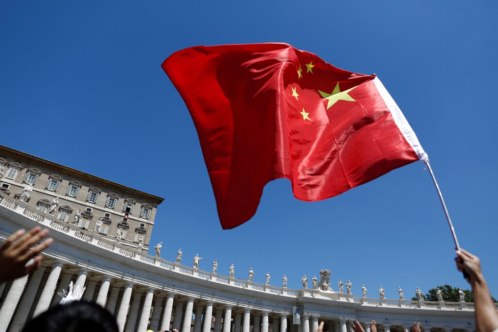 A man waves a Chinese flag as Pope Francis leads his Sunday Angelus prayer in Saint Peter's square at the Vatican July 17, 2016. REUTERS/Tony Gentile - RTSICWA