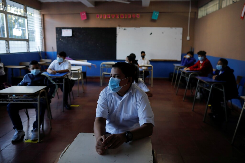 Students wearing protective face masks are seated adhering to social distancing guidelines while attending a class, as students return to classes for 2022 school year, amid the coronavirus disease (COVID-19) pandemic, in San Salvador, El Salvador January 31, 2022. REUTERS/Jose Cabezas