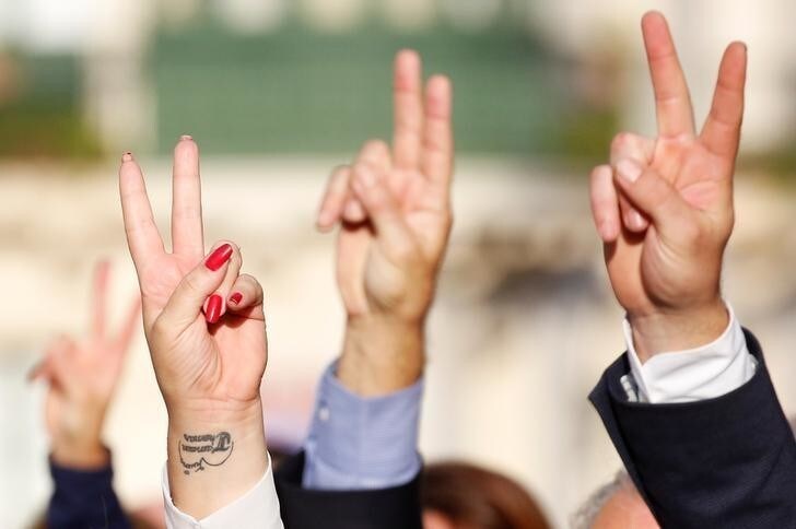 People sing the Maltese national anthem as they show a peace sign while attending a funeral ceremony of journalist Daphne Caruana Galizia, who was murdered in a car bomb attack, at the Rotunda Parish Church in Mosta, Malta, November 3, 2017. REUTERS/Alessandro Bianchi