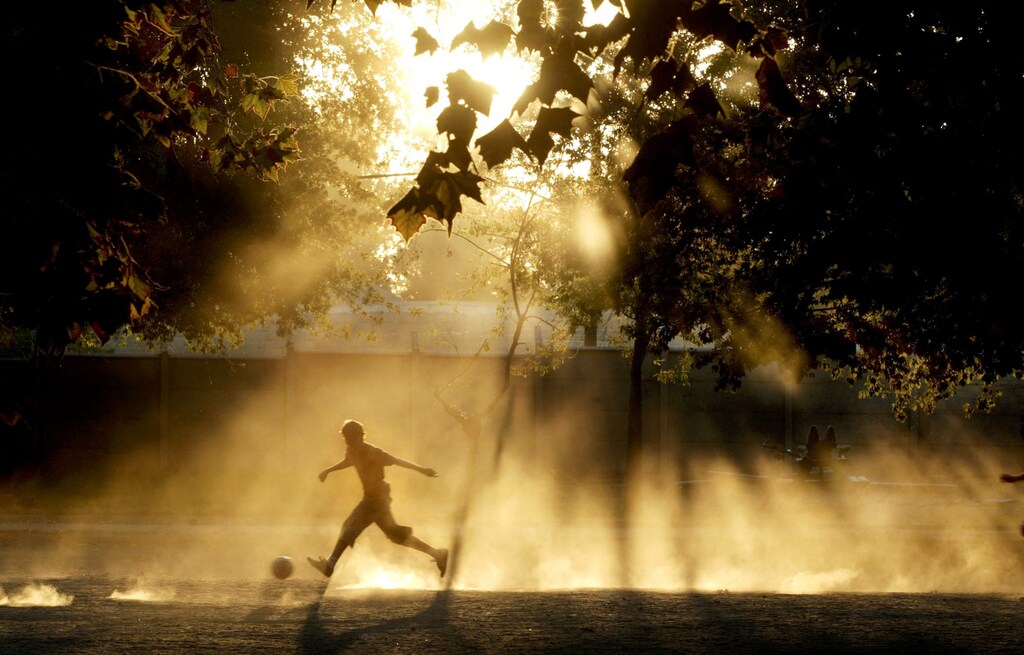 PICTURES OF THE YEAR 2004 A Chilean boy plays soccer at the "Normal Park" in Santiago, March 19, 2004, on the last day of summer. REUTERS/Carlos Barria BEST QUALITY AVAILABLE - RP5DRIENYTAA