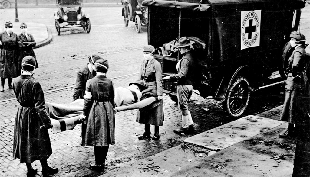 A photo of a body being lifted on a stretcher into an ambulance, during the 1918 flu pandemic