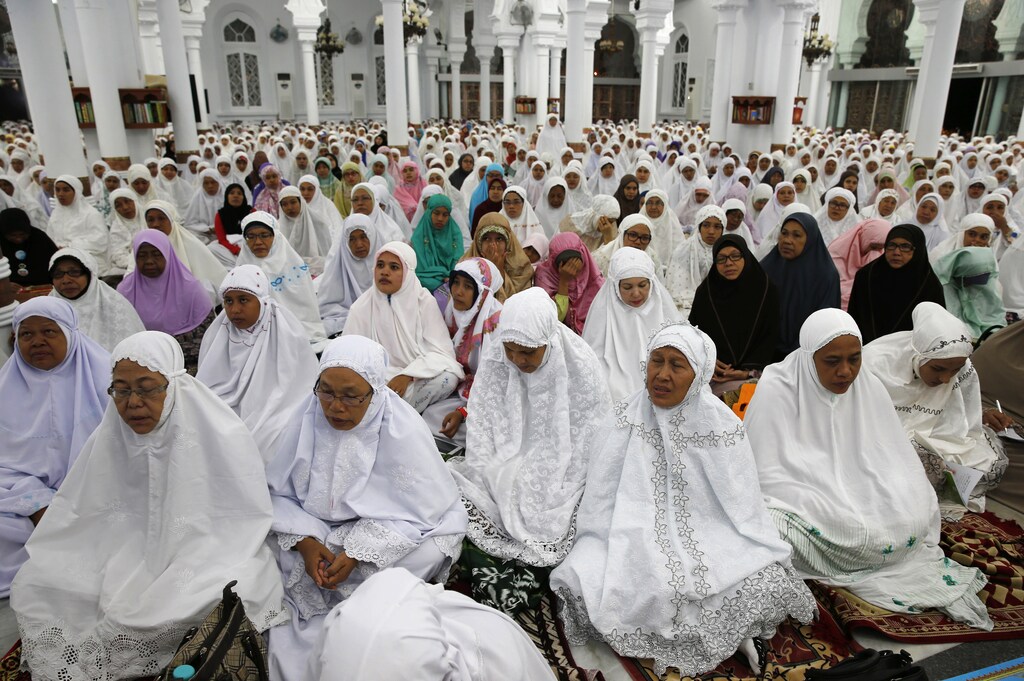 Acehnese women attend a mass prayer for the 2004 tsunami victims at Baiturrahman Grand Mosque in Banda Aceh, December 25, 2014. Thousands of Indonesians gathered on Thursday to pray at the mosque that was one of the few buildings left standing in Banda Aceh, the city flattened by the Boxing Day tsunami that killed at least 226,000 people 10 years ago. REUTERS/Beawiharta (INDONESIA - Tags: DISASTER ENVIRONMENT RELIGION ANNIVERSARY) - GM1EACQ00M101