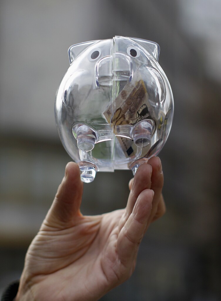A man holds a transparent plastic piggy bank during a protest against major banks in Frankfurt October 29, 2012.